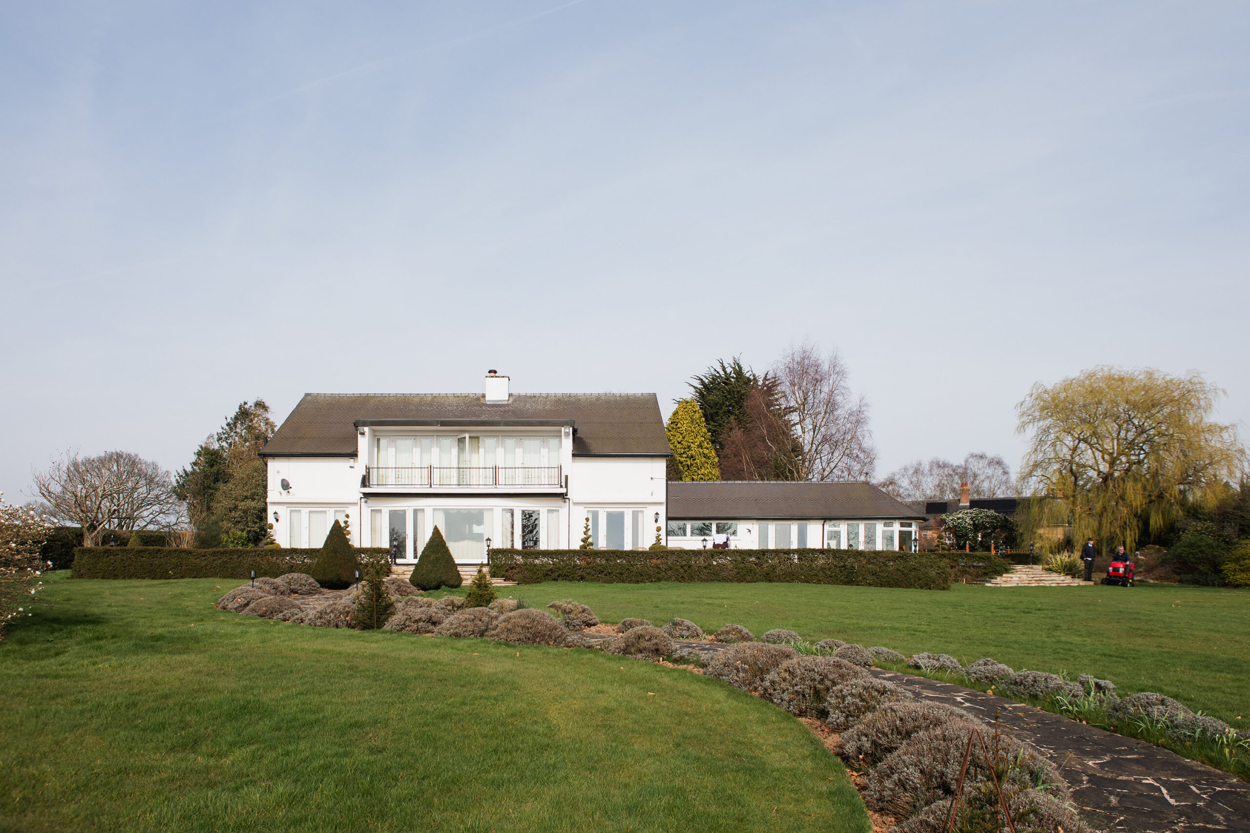 Existing rear view of Swallows Flight, showing the two-storey house, single-storey side wing and landscaped garden